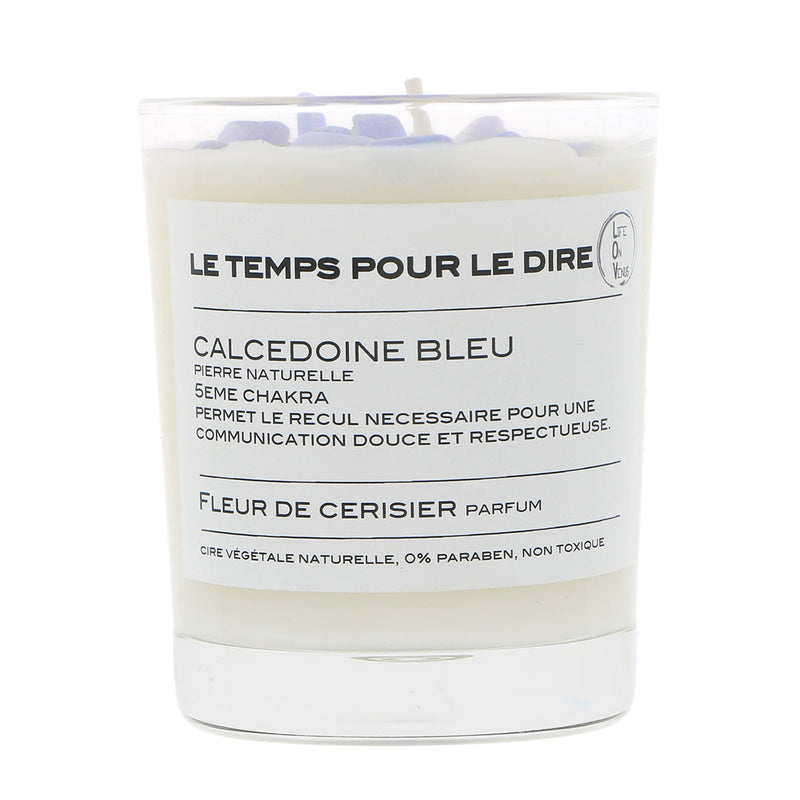Bougie parfumée LE TEMPS POUR LE DIRE avec pierres de calcédoine bleue, indiquée pour le 5ème chakra, parfumée à la fleur de cerisier, présentée dans un pot en verre. La bougie est fabriquée à partir de cire végétale naturelle, sans parabène, et non toxique.