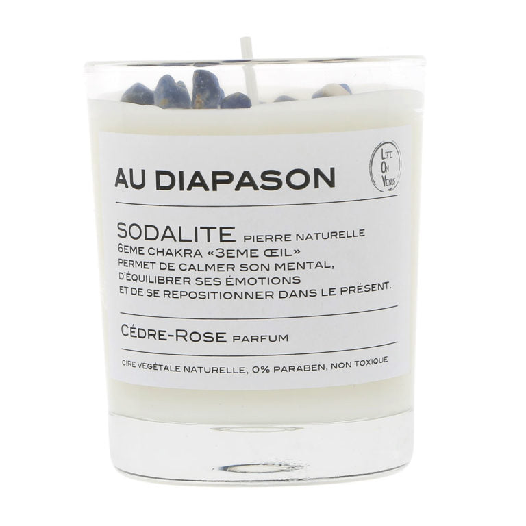 Bougie parfumée AU DIAPASON avec pierres de sodalite, indiquée pour le 6ème chakra ‘3ème œil’, parfumée au cèdre-rose, présentée dans un pot en verre.